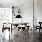 white painted brick walls white painted ceiling dark concrete floor wooden varnished dining table wooden varnnished dining chair black metal pendant lamp white painted wooden open storages