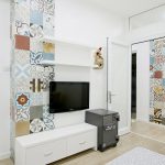 cool apartment design with small wall mount tv and long drawer with eclectic colorful mosaic tile on the wall in laminate flooring