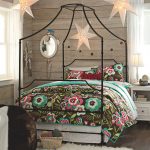 cute star hanging lamp colorful floral printed bedding set white side table white table lamp hardwood flooring wood wall white framed windows white curtains dark brown beanbag chair white round mirror