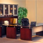 U shape desk with glossy black top desk and glass-door top cabinet system and drawer feature a black leather office chair a files arrangement