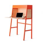 folding student standing desk in orange color a laptop and a white cup
