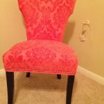 strong-pink color reading chair with brocade coat and dark wood legs