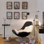 modern black chair with soft white blanket a magazine storage floating desk in black sophisticated standing lamp some painting as wall decorations minimalist black round table  round brown carpet