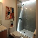 walk-in shower idea with frameless glass door and  shower appliance a white toilet fixture  a bathroom vanity with undermount white sink plus faucet a frameless decorative mirror for bathroom