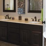 bathroom remodelling with wooden vanity units plus sinks and mirror and towel holder and green grass pot and floor tiles