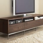 long TV console in black wood finishing and undershelves a large flat TV  and DVD player two boxes for storage white and soft fury carpet
