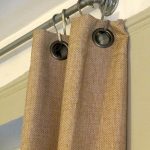 metal half curtain rod with hooks and brown curtain