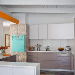 white kitchen cabinets for top area and light grey under kitchen cabinets with stainless steel handles L-shaped countertop in white