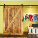 cheerful sliding wooden barn doors for closets in traditional style combined with hanging jackets and bag plus wooden storage and hardwood flooring with mats