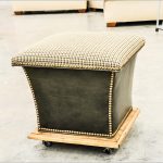 elegant black cream ottoman storage design with wheels and wooden accent and table cloth patterned bolster