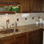 elegant white groutless backsplash design above cream patterned marble top on wooden cabinetry with transparent storage with modern sink
