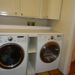 multipurpose cabinet design for washer and dryer with double machine upon brown tile flooring design bathed in dull white tone