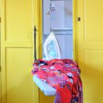red cloth with iron upon white ironing board idea inside yellow storage cabinet with metal holder