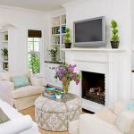 room design with white fireplace mantel and white sofa series plus their pillows wall mount TV set built in books shelves and brown rug designed by Better Homes and Gardens