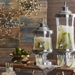 stunning glass beverage dispenser with metal spigot for juice drinks plus lemonade glass and lighting plus limes and silver footed and lid