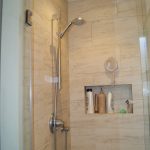 Porcelain tiling idea for doorless shower built in shelf for storing bathing supplies heldhand showerhead single recessed lighting