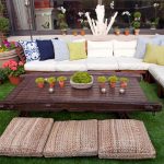 fresh and stunning brown wooden kid friendly coffee table design with potted plants with rattan pouf before sectioned white sofa