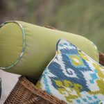 Light green bolster pillow and a throw pillow in randomly colorful patterns