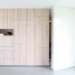 Simple minimalist built in cabinets with single shelf made of light wood
