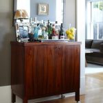 Darker coated wooden bar cabinetry with wheels