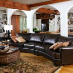 ethan allen leather furniture with dark brown leather  curved sofa together with round rattan coffee table with wooden top in traditional living room