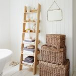 rustic-ladder-shelf-in-the-bathroom-for-towels-and-small-rounded-mirror-near-bathtub-and-square-mirror-hang-on-the-white-wall