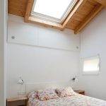 simple small atttic bedroom design with floral bedding sheet idea with square skyligt and wooden ceiling
