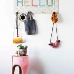 unique and simple coat rack design idea with hellow written on board with hooks for bags and pink table on patterned area rug