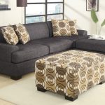 Deep grey apartment sized sectional model with chaise and accent pillows an ottoman table with modern pattern round glass table with metal base