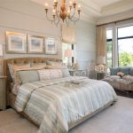 gorgeous bedroom in american house design with glass window and gray sofa and creamy bedding with chandelier and white area rug