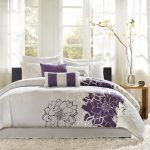 A bedding set with purple flower motif and less gray decorative motifs white fluffy area rug modern wood side table in modern style