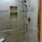 Larger standup shower idea with frameless glass door and wall mounted showerhead and handheld showerhead built ini shower shelves