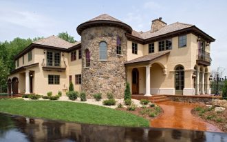 Tuscan costum house idea with random patterned stone walls high and curved doors and windows dark glass windows beautifulfront yard