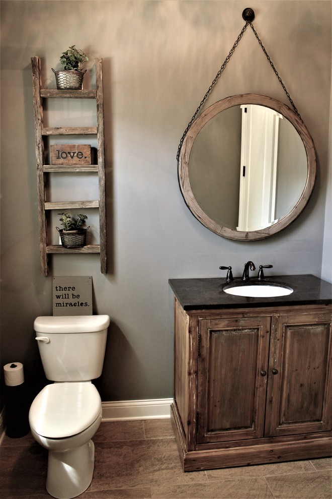 rustic powder room idea old and shabby wood cabinets marble countertop with small undermount sink rounded mirror with shabby wood frame and hanging chain shabby & old ladder shelves on wall