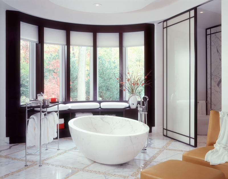modern bathroom idea freestanding marble tub marble tiled floors with stone accents chrome bathroom appliances dark wood framed windows