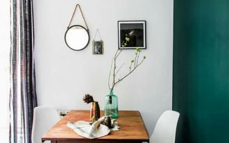 Scandinavian style dining room midcentury modern wood dining table midcentury modern dining chairs black white tile floors deep green wall accent