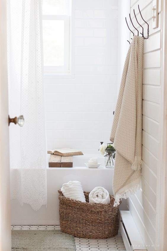 crisp white shower curtains woven baskets for towels hanging pastel towel white tile walls built in bathtub in white