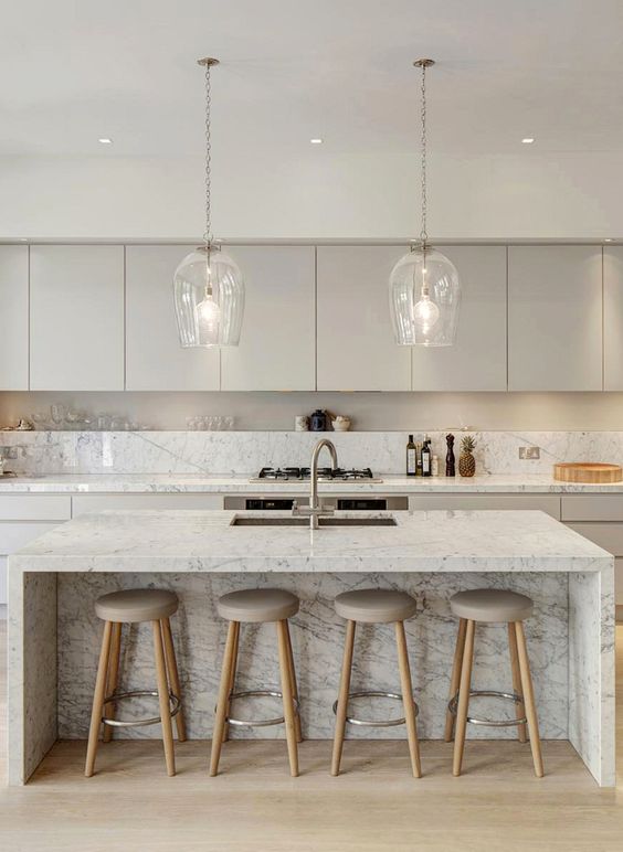flat surface cabinets on top white kitchen counter with marble backsplash marble kitchen island with sink and faucet simple bar stools with gray round cushion and light wood legs