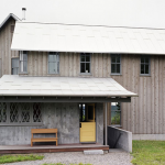 a pole barn house in pale color theme with soft yellow Dutch door as the front door
