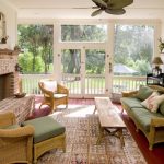 medium size sunroom with a comfy sofa with green mattress and decorative pillow a long wood table looks like a long wood bench a pair of rattan chairs with table a big basket bricks fireplace
