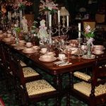 luxurious and vintage dining table design with furnished table and wooden framed chairs with cream bolster and candle stick and great centerpiece