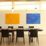 Modern dining room idea with attractive color tones of yellow red and blue two modern pendant lamps a set of dining furniture with large table for eight dining chairs