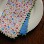 sweet colorful  balloon patterned cloth napkin design with chevron edging with blue background on white plate with spoon