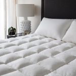Cozy mattress pad IKEA for king bed with pillows and black headboard