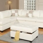 Slim white sectional with single chaise and white light brown throw pillows white ottoman with linen storage underneath small light grey wool rug wood floors