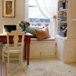 beige shabby cic bookshelves with banquette and wooden desk and white chair and glass window and wooden floor