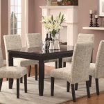 classic white upholstered dining chair design on white rug with wooden table with glass window and orchid