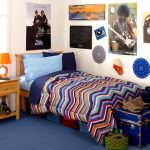 cheerful college dorm room idea wth chevron sheet and blue bedding and wooden nightstand and wall pictures and teasure box and blue flooring