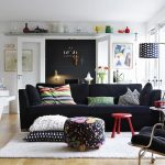 modern and luxurious interior with black sofa design and black plaid chairs and floral pouf and curved floor lamp and wooden floor and white area rug