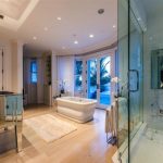 adorable and luxurious bathroom mansion deisgn with walk in shower and white bathtub and curved bay window and wooden floor